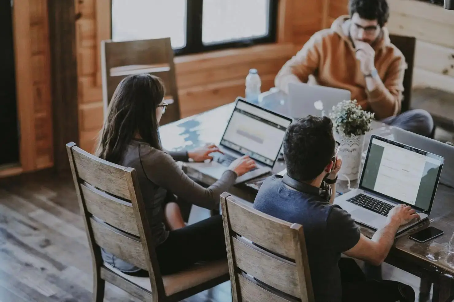 Equipo tecnológico colaborando en el diseño de software en un espacio de trabajo moderno.